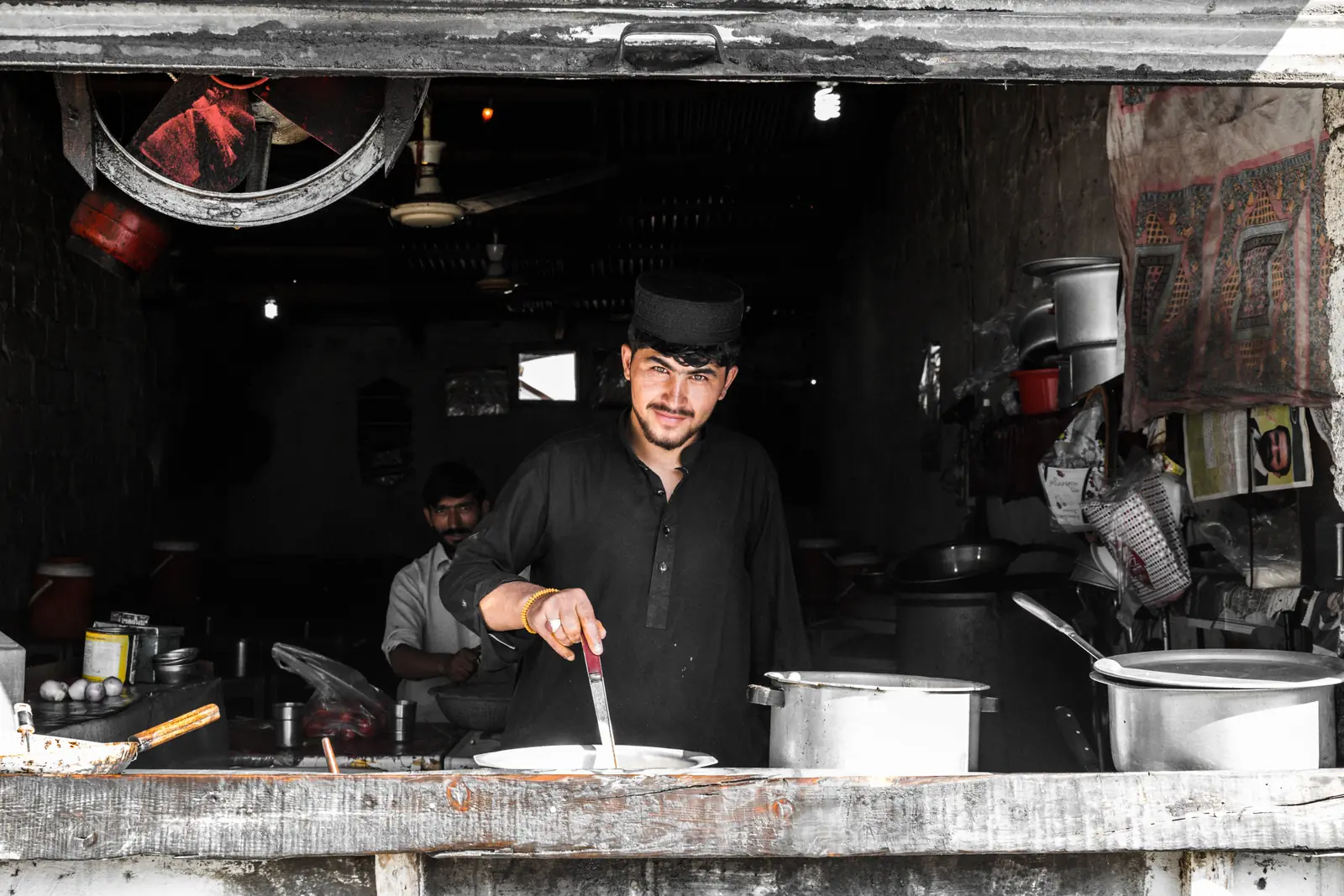 Cook preparing food in a Pakistani restaurant kitchen